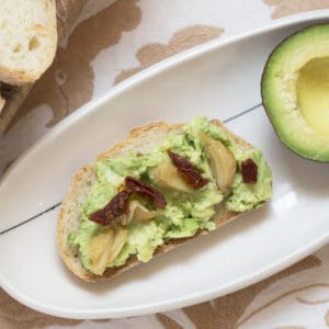 Roasted Garlic Avocado Toast with Sun Dried Tomatoes