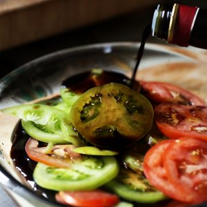 Thinly slice your tomatoes, and soak in balsamic vinegar for about 5 minutes.