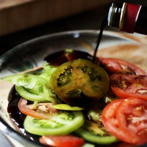 Thinly slice your tomatoes, and soak in balsamic vinegar for about 5 minutes.