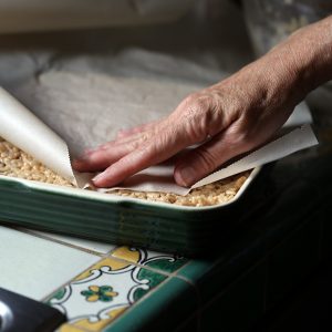 Using a sheet of parchment paper takes the mess out of pressing the crispy mixture into your dish.