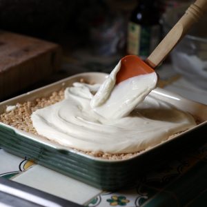 Using a rubber spatula, spread the melted white chocolate evenly across the top of the crispy mixture.