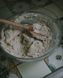 Bowl and spoon stirring Rosemary Sea Salt Crackers with Truffle Oil