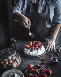 Spooning Hibiscus syrup over the pavlova