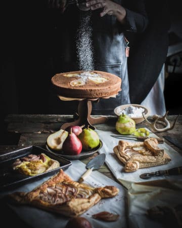 Dusting powdered sugar on Pear Cake with Black Pepper and Buttermilk