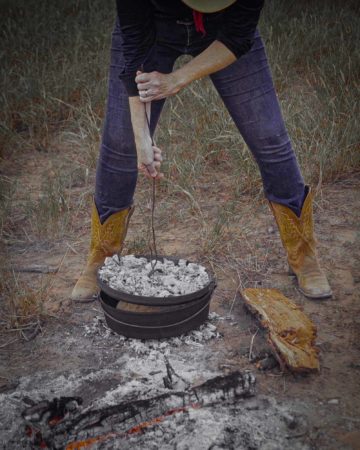 cowgirl standing over dutch oven