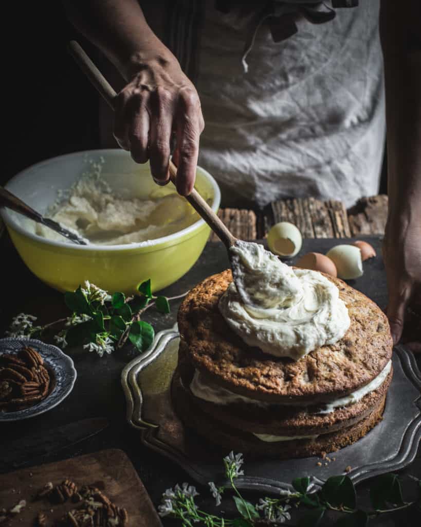 hands frosting a cake