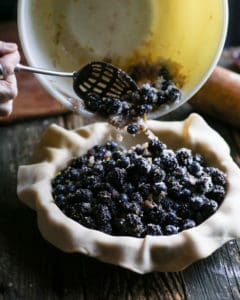 pouring berries into pie crust