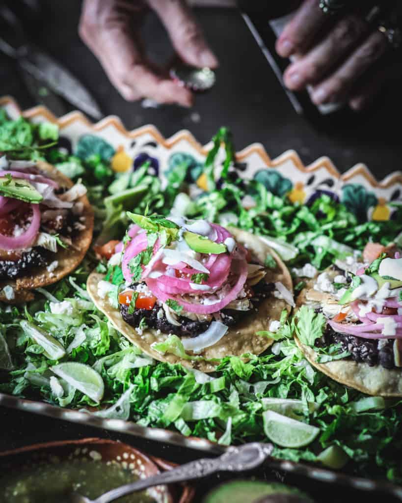 hands with tostada and cebollas en esabeche