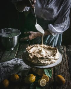 filling pouring into Brown Sugar Pavlova on Pedestal