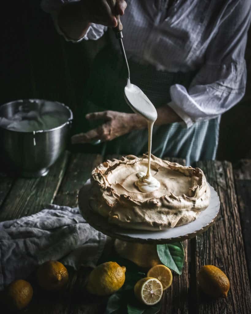 filling pouring into Brown Sugar Pavlova on Pedestal