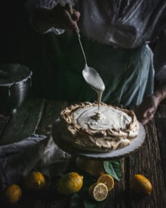 filling pouring into Brown Sugar Pavlova on Pedestal