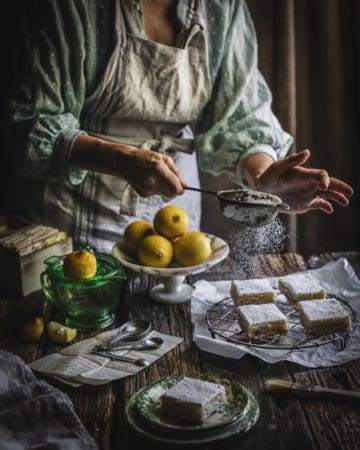 woman garnishing lemon bars