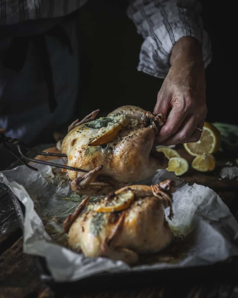 woman serving tray with Lemon Sage Cornish Game Hens