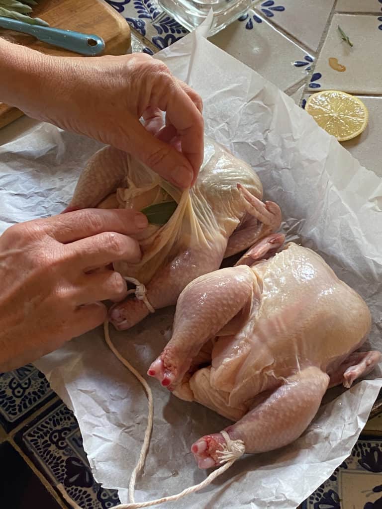 woman preparing uncooked Lemon Sage Cornish Game Hens