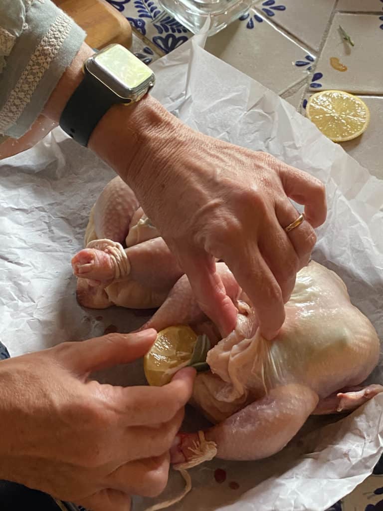 woman preparing uncooked Lemon Sage Cornish Game Hens