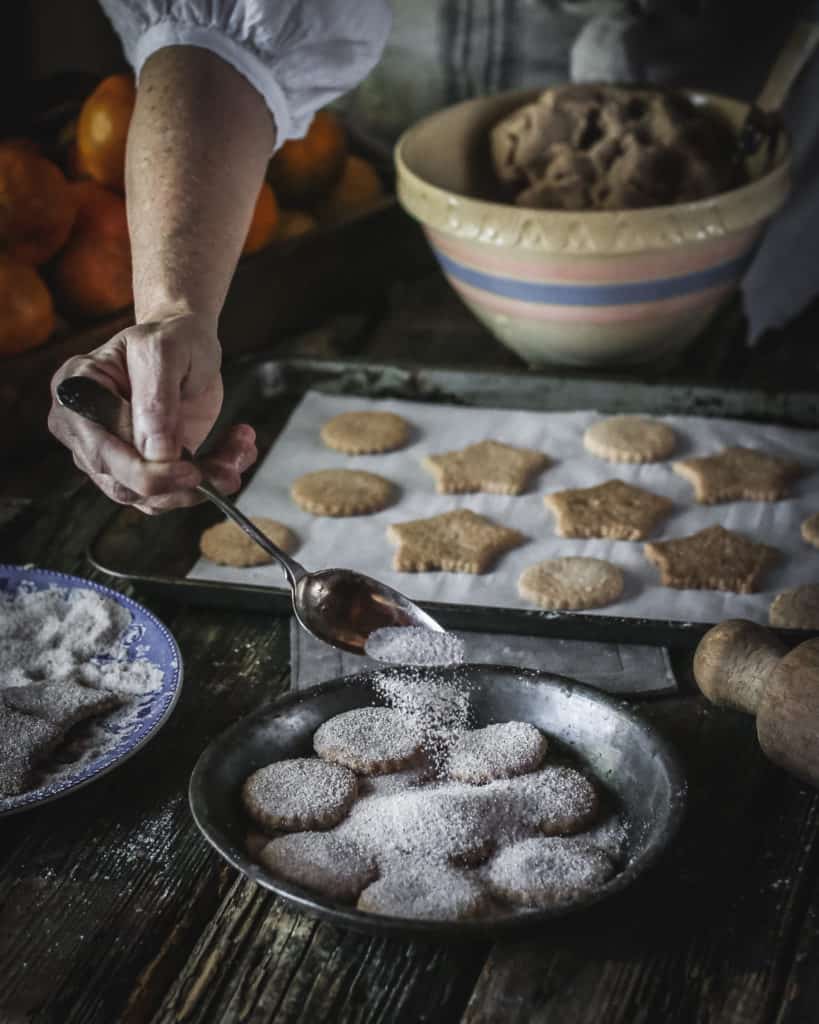 hand sprinkling sugar over cookie