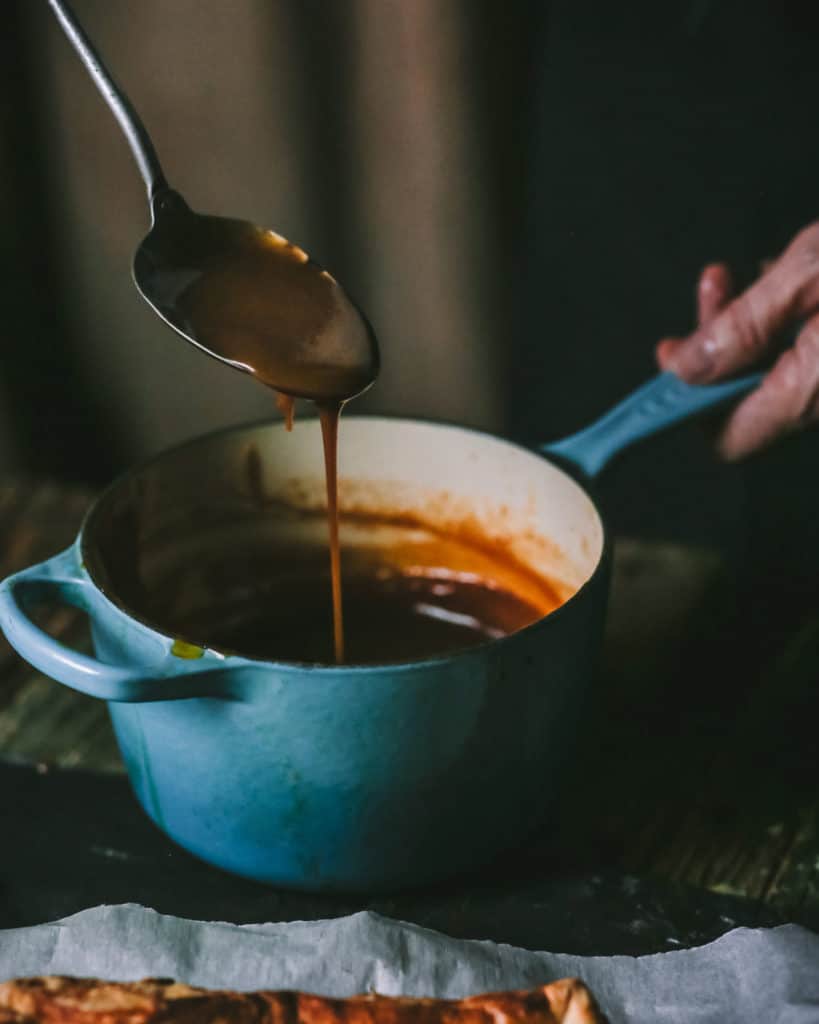 close up of butterscotch sauce pouring from spoon