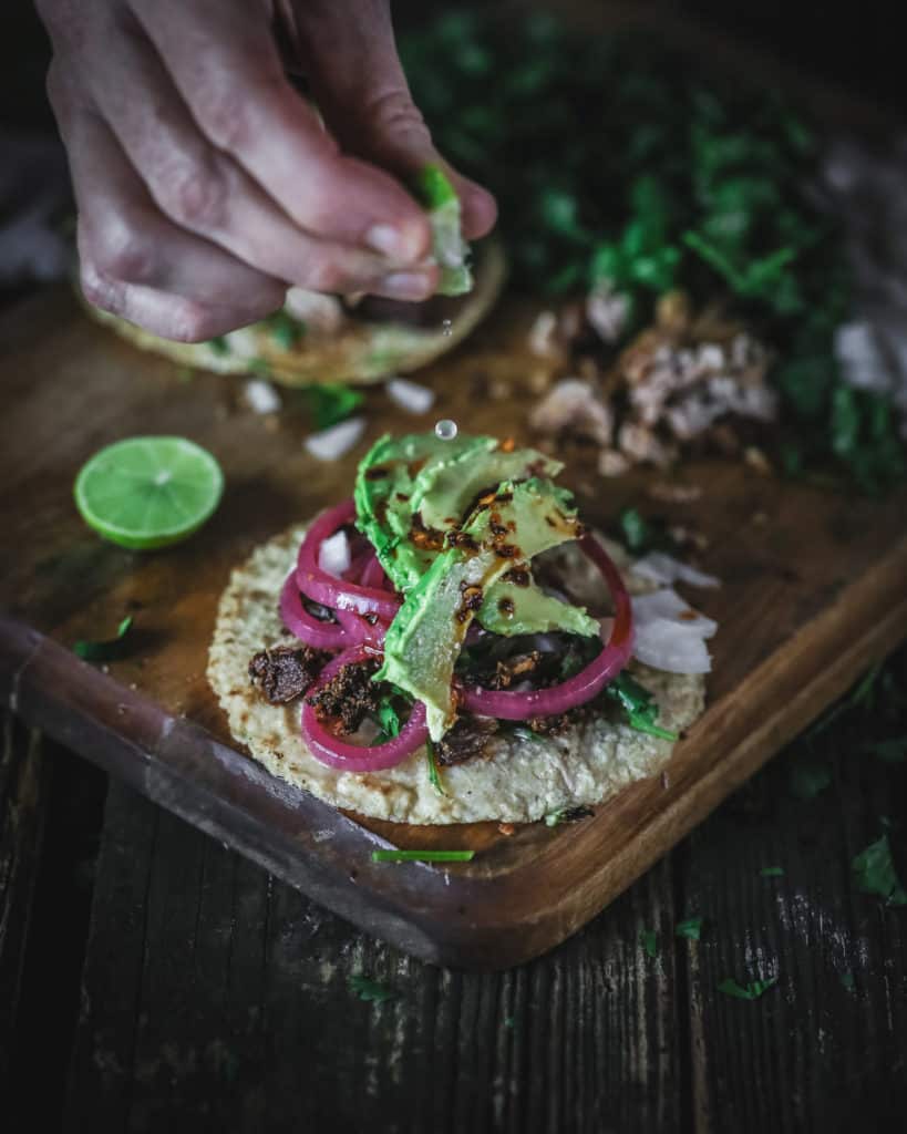 hand squeezing on pork carnitas taco