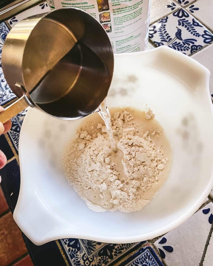 water pouring into bowl of tortilla mix