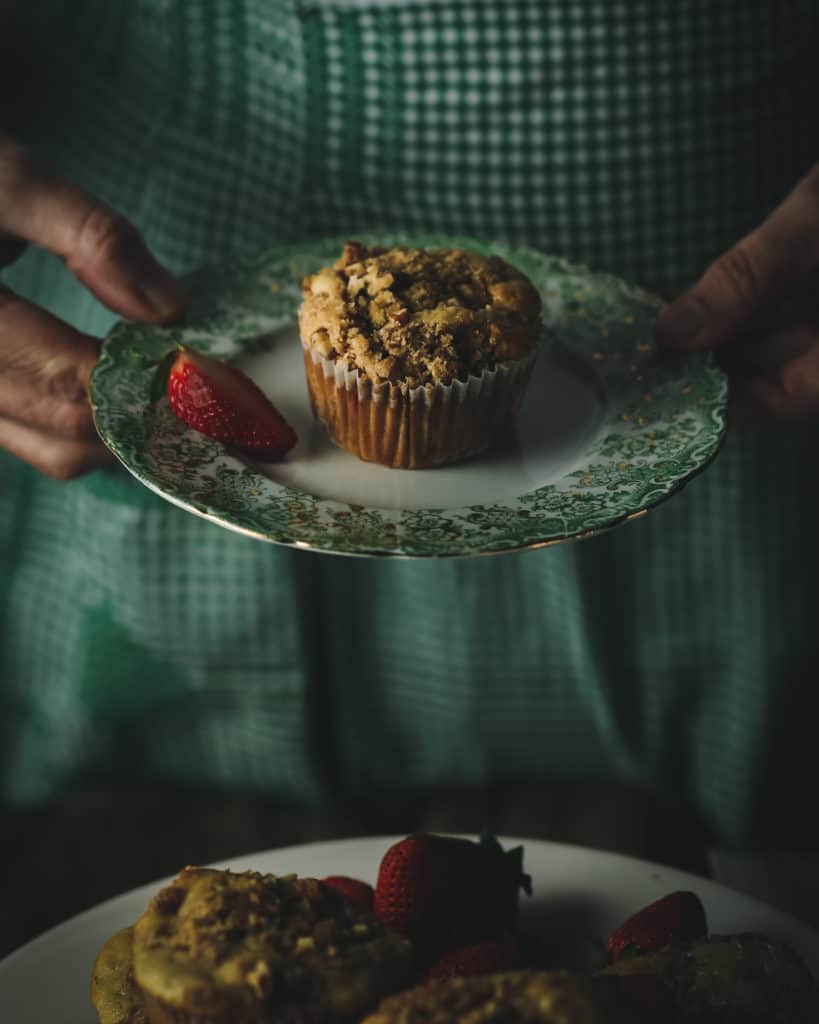 hands holding muffin on a plate