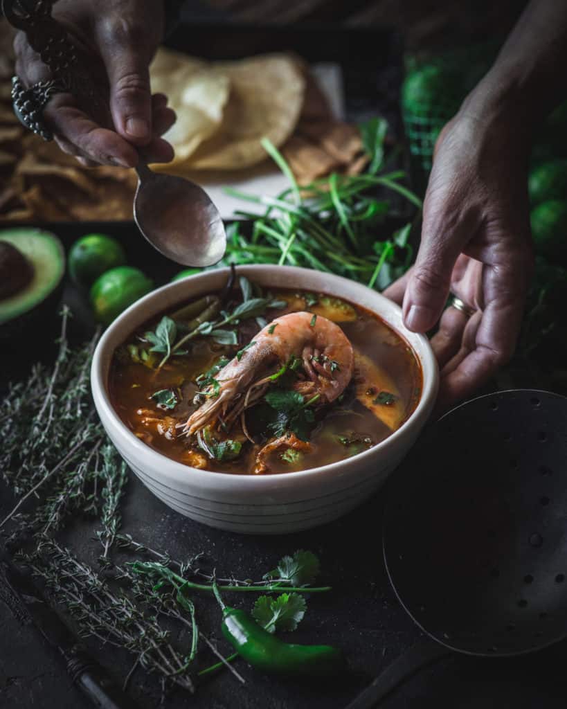 hand serving caldo de mariscos