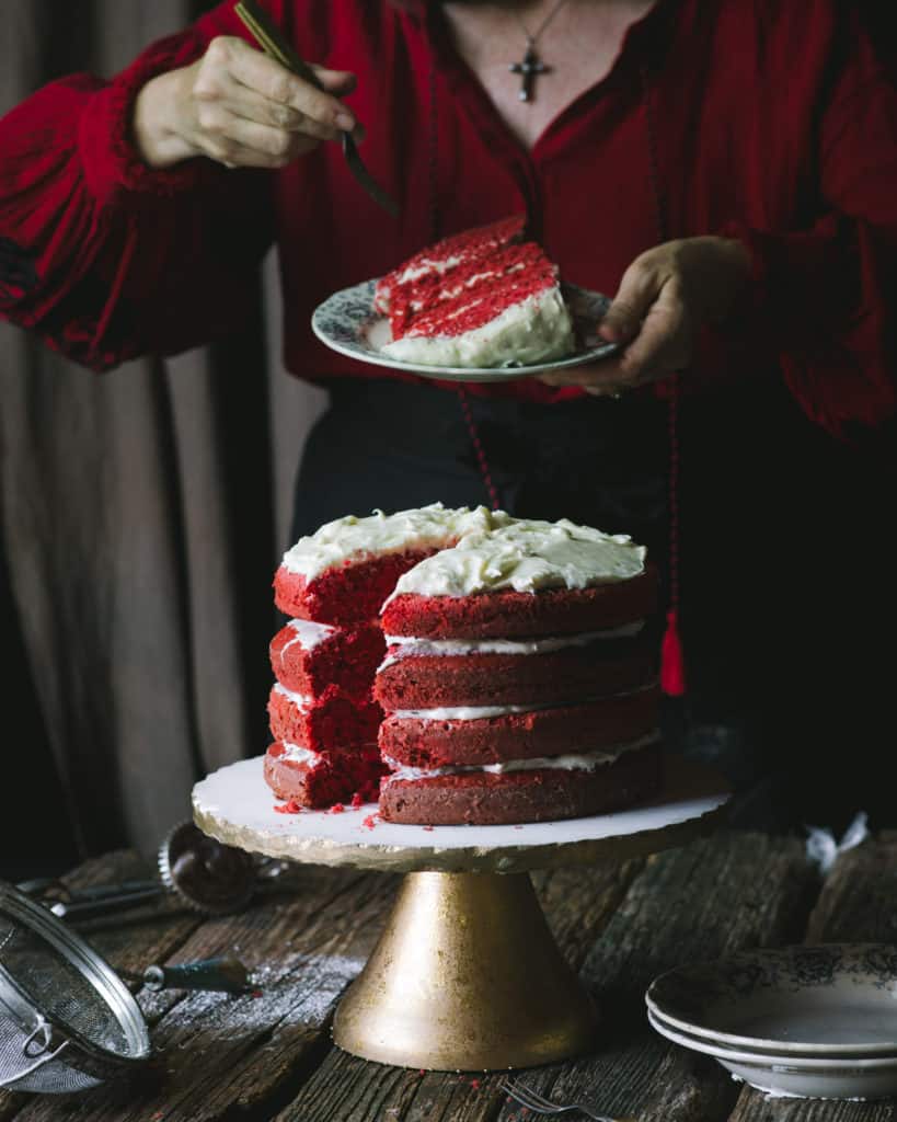 woman serving red velvet cake