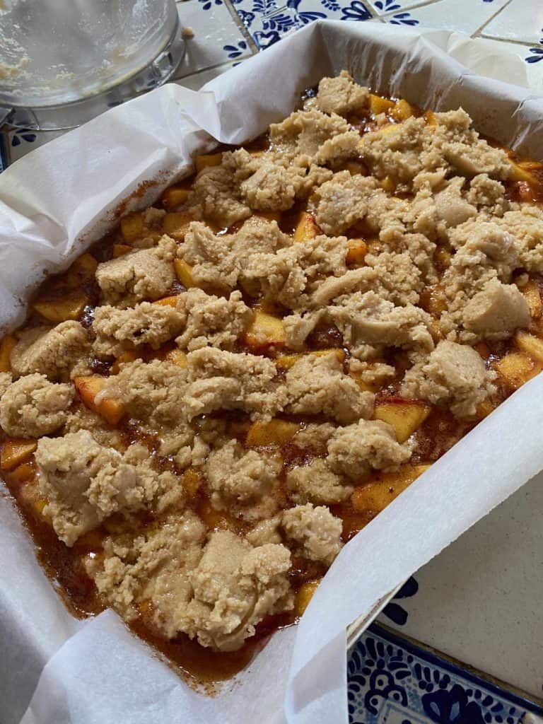 baking pan with peaches and uncooked dough