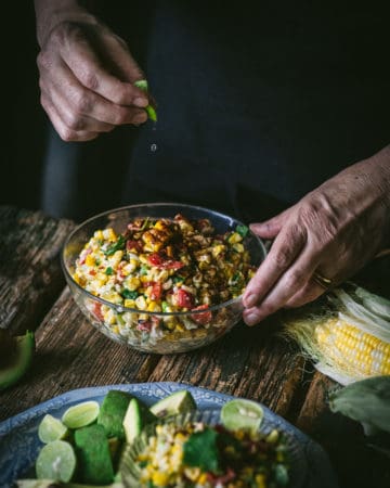hands with bowl of corn salad