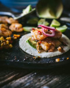 close up of shrimp with onions on tortilla