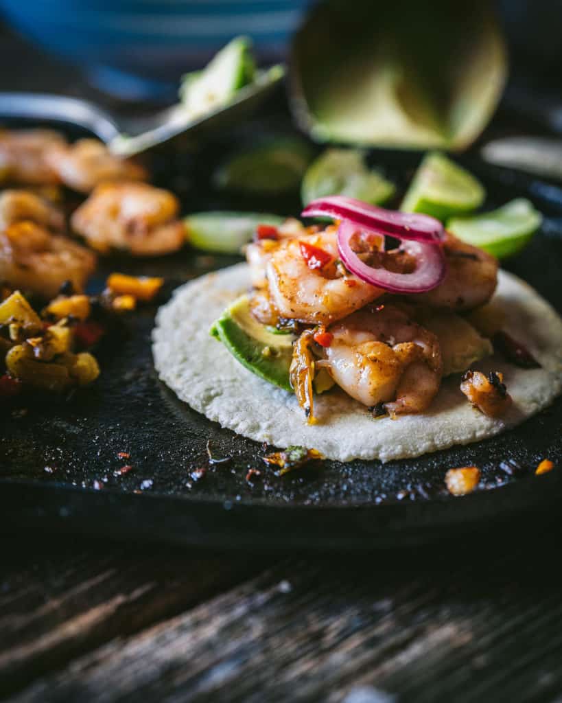 close up of shrimp with onions on tortilla