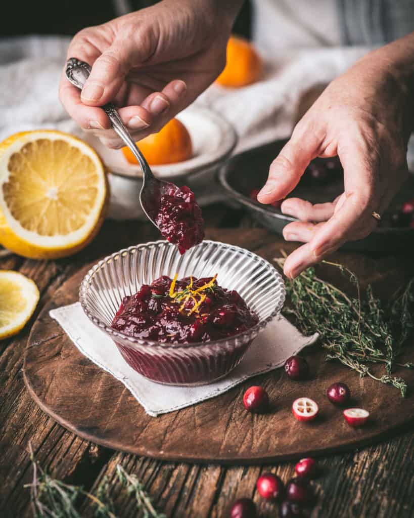 hands serving Cranberry Sauce with Orange Zest and Chile Piquin