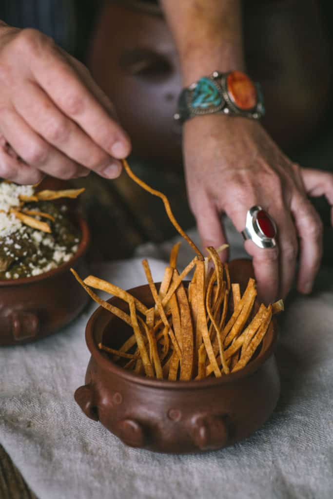 woman hands and bowl of thin tortilla chips