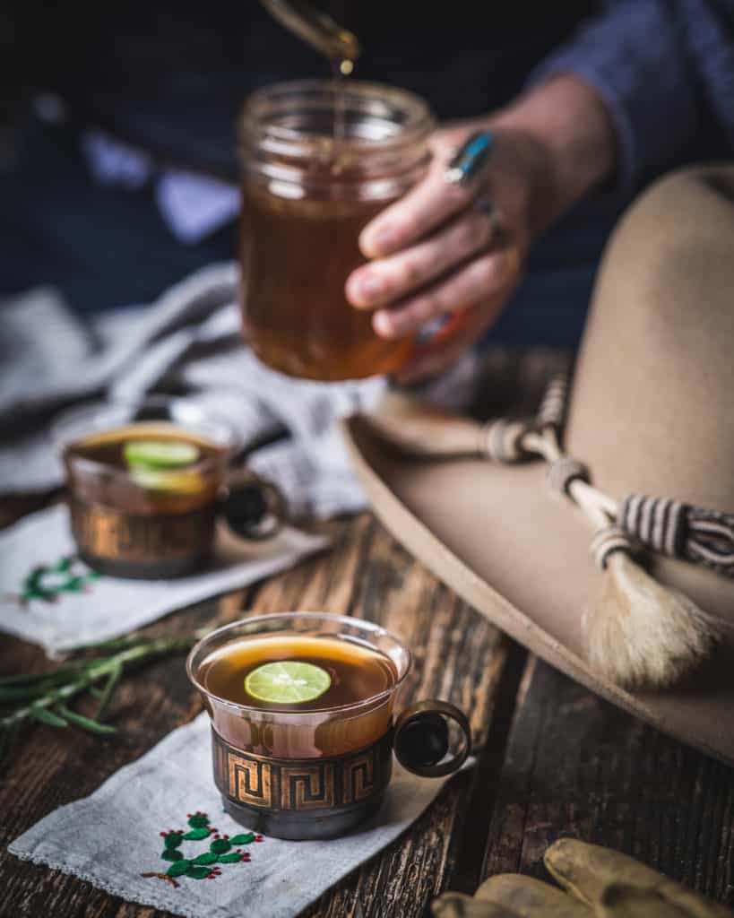 cup of Hot Bourbon tea with woman & jar of honey