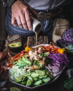 pouring dressing over salad