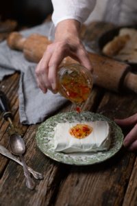 pouring jelly on cream cheese