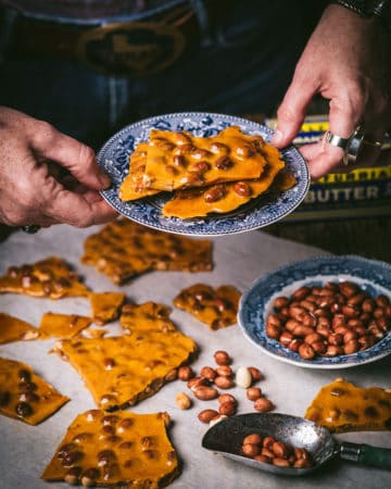 woman holding plate of microwave peanut brittle