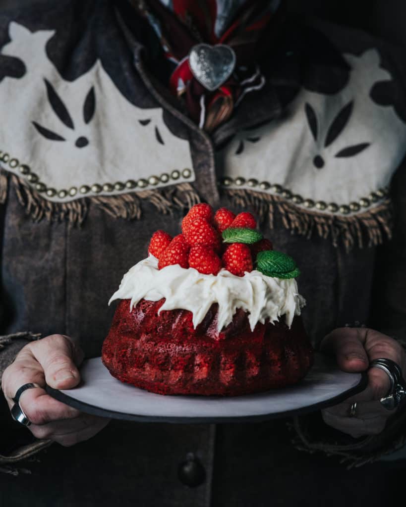 woman holding small cake on platter