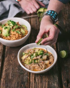 woman's hand squeezing lime juice over fideo