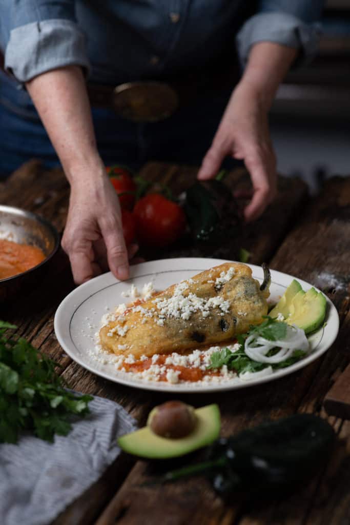 woman with plate of chiles rellenos