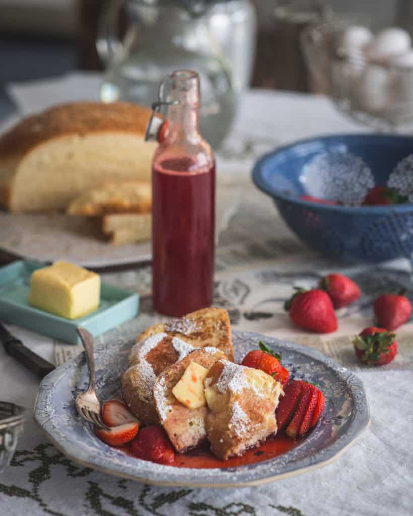 plate of french toast with bottle of strawberry syrup