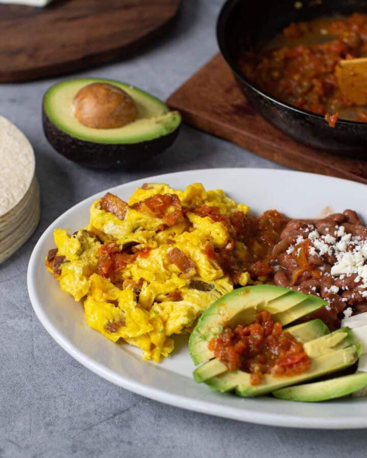 plate of eggs, beans, avocado cheese