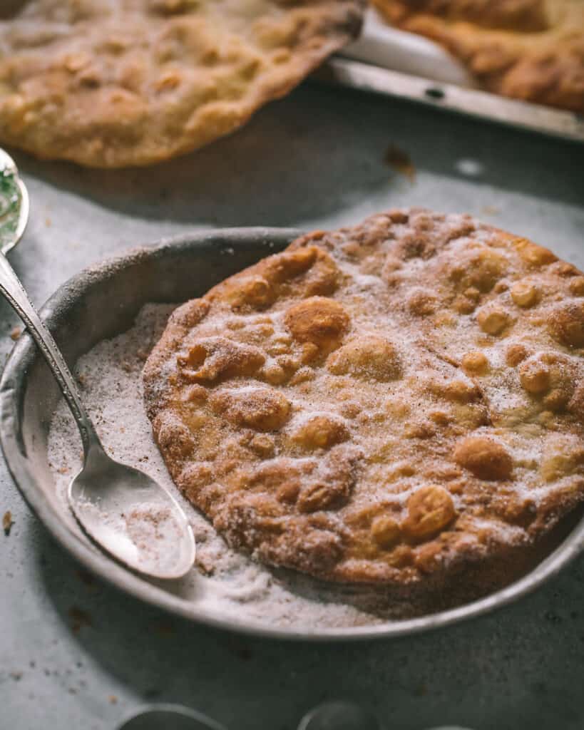 buñuelo on a plate of sugar