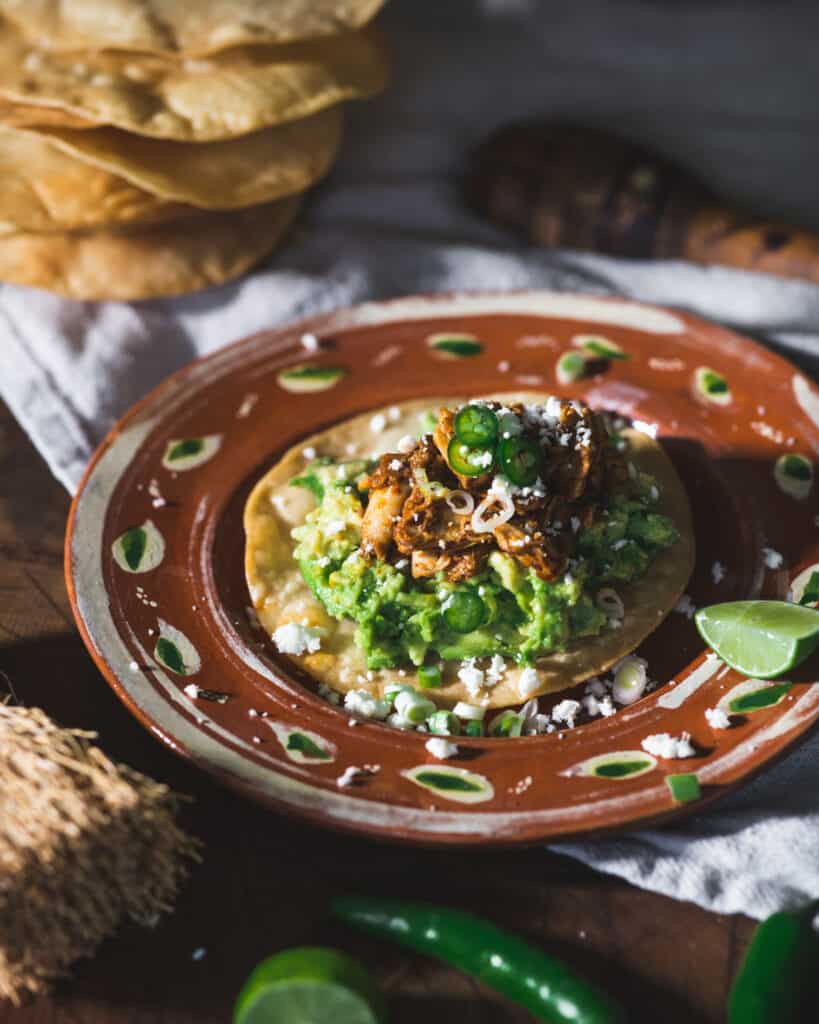 tostada on a plate with Chicken in Adobo sauce