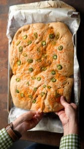 hands breaking Jalapeño Cheddar Foccacia Bread