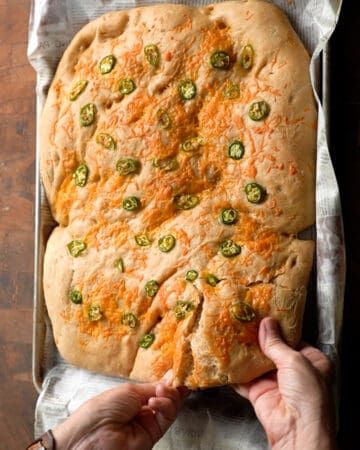 hands breaking Jalapeño Cheddar Foccacia Bread