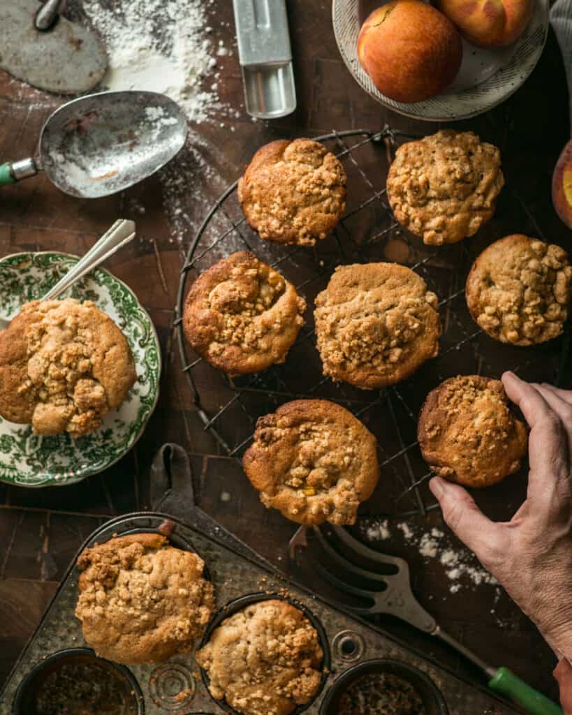 hand selecting a peach streusel muffin