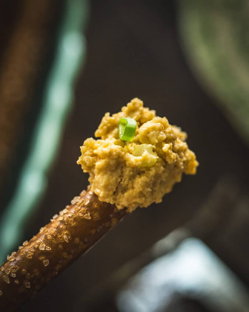 close up of cheese spread on pretzel stick