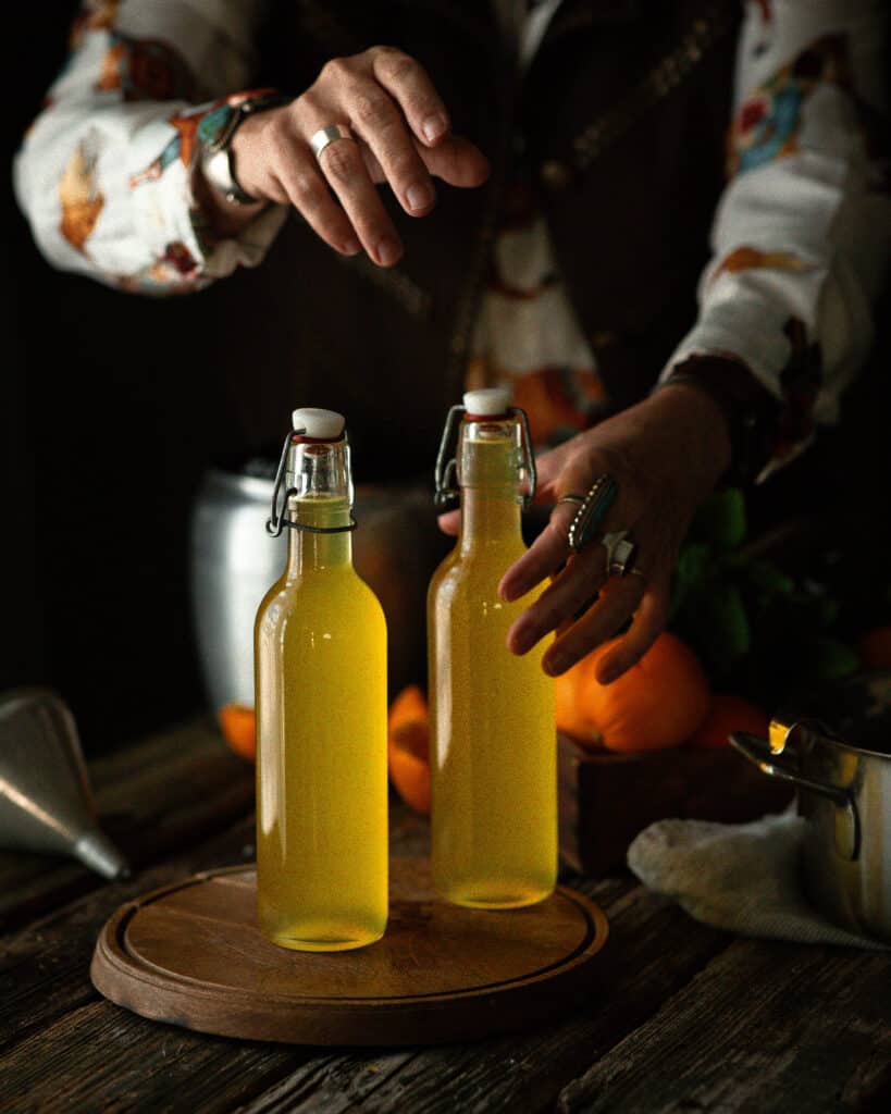 Woman sealing bottles of Orange Simple Syrup