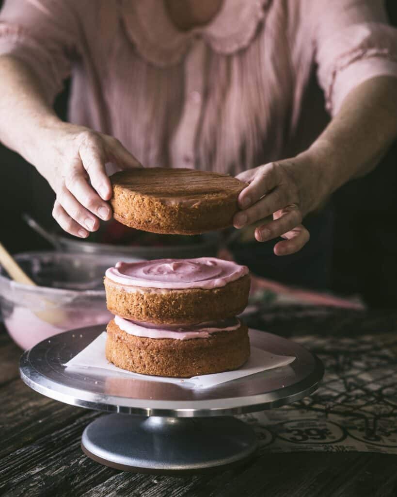 woman frosting Strawberry cake 