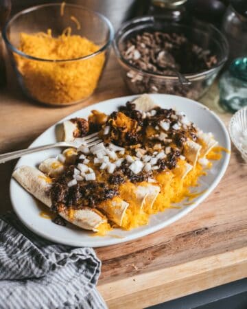 cheese enchilads on a platter with a fork